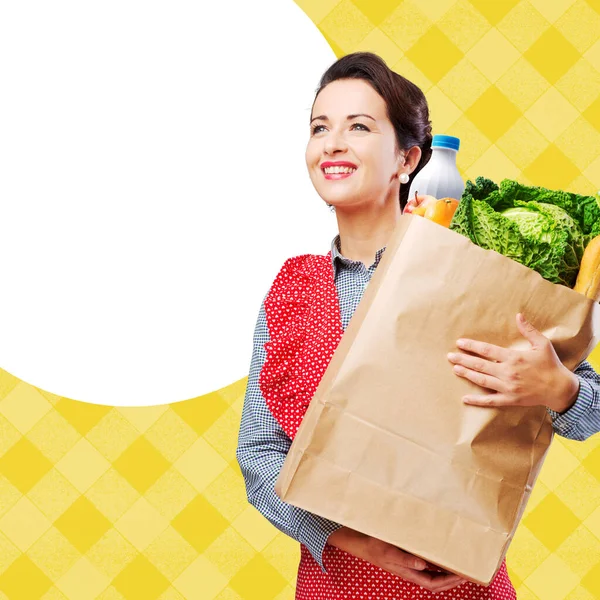 Uśmiechnięta Rocznika Kobieta Fartuch Trzymając Zakupy Worek Spożywczy — Zdjęcie stockowe