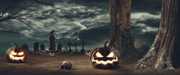 Horror Halloween background with pumpkins and old scary cemetery