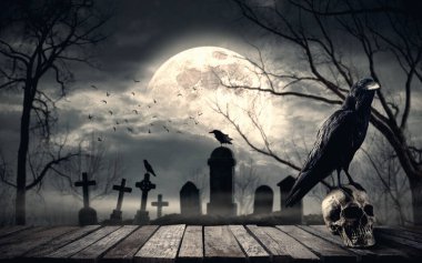 Gece yarısı ürkütücü bir karga insan kafatası üzerinde dururken ürkütücü eski mezarlık arka planda dolunay: korku ve Cadılar Bayramı konsepti
