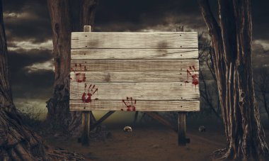 Ormanda kanlı el izleriyle eski, yıpranmış ahşap tabela: korku ve Cadılar Bayramı kavramı