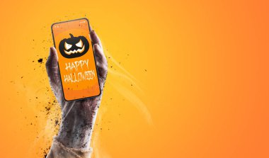 Cadılar Bayramı dilekleri, bayramı ve kutlama konseptiyle akıllı telefon tutan zombi.