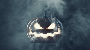 Funny Halloween pumpkin glowing in the dark surrounded by fog clipart