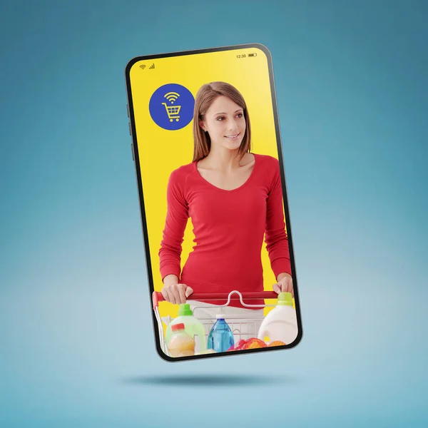 Online grocery shopping app: smiling woman pushing a full shopping cart in a smartphone screen