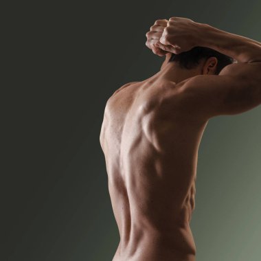 Çekici şehvetli adam kaslı sırtını gösteriyor, formda ve egzersiz konseptini taklit ediyor.