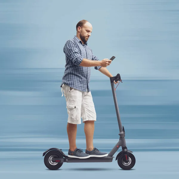 Homem Descuidado Usando Smartphone Enquanto Monta Uma Scooter Elétrica — Fotografia de Stock