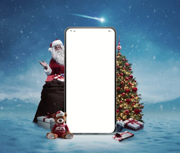 Big smartphone with blank screen, Santa Claus, gifts and decorations: Christmas shopping online