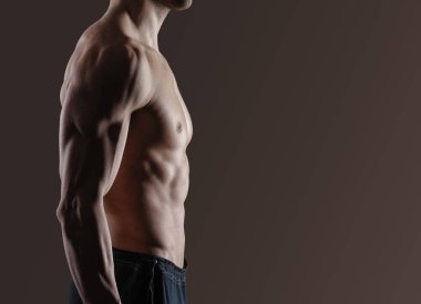 Formda adam poz veriyor ve kaslarını gösteriyor, profil görüşü