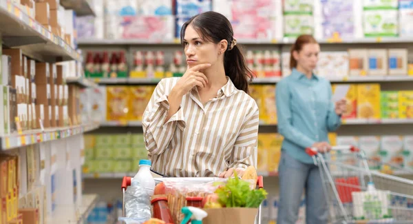 Mladá Žena Supermarketu Tlačí Vozík Plný Čerstvých Potravin Dívá Regál — Stock fotografie