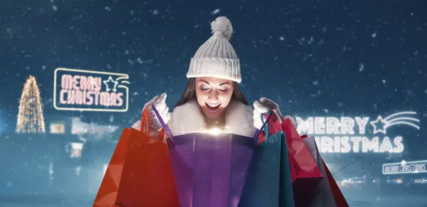快乐的女人在雪地里买圣诞礼物 她在看包里的东西 — 图库照片