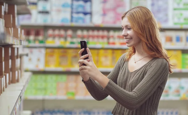 Молодая Женщина Делает Покупки Супермаркете Проверяет Информацию Еде Помощью Приложения — стоковое фото
