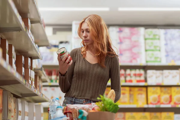 Mladá Žena Dělá Nákupy Supermarketu Drží Plechovku Kontroluje Informace Etiketě — Stock fotografie