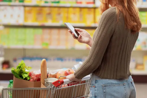 Mulher Fazendo Compras Supermercado Usando Seu Smartphone — Fotografia de Stock