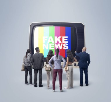 Televizyonda sahte haber izleyen bir grup insan, eski bir televizyonun önünde durup ekrana bakıyorlar.