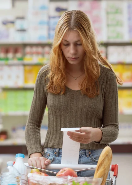 Женщина Толкает Полную Корзину Супермаркете Проверяет Длинную Квитанцию Бюджет Концепцию — стоковое фото