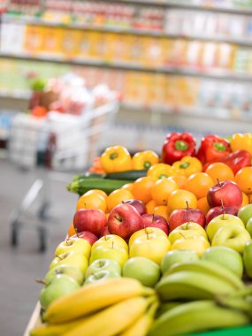 Süpermarketin üretim bölümünde taze organik sebzeler ve meyveler, market alışverişi ve sağlıklı gıda konsepti.