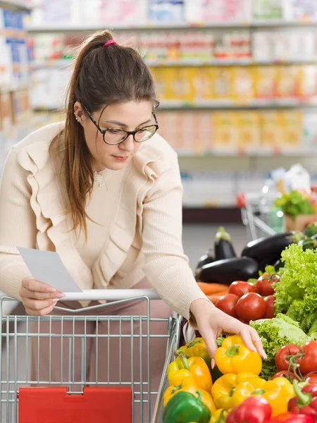 スーパーマーケットで食料品の買い物をしている女性 彼女は生産セクションで新鮮な有機野菜を購入しています — ストック写真