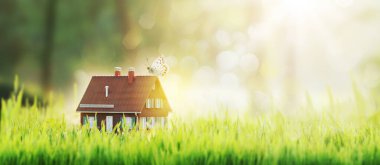 Çimlerin üzerinde şirin bir model ev: emlak ve çevre dostu ev, kopyalama alanı