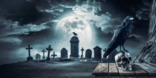 Creepy old cemetery at night with spooky crow standing on a human skull, full moon in the background: horror and Halloween concept