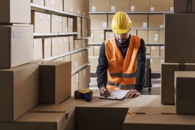 Warehouse worker holding a clipboard and checking packages, logistics and shipment concept clipart