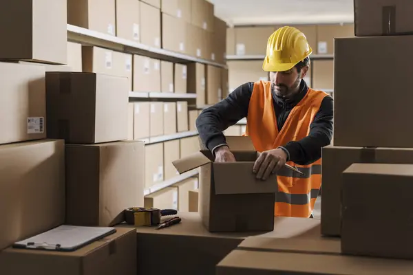 stock image Warehouse worker preparing a package for shipping, logistics and commerce concept