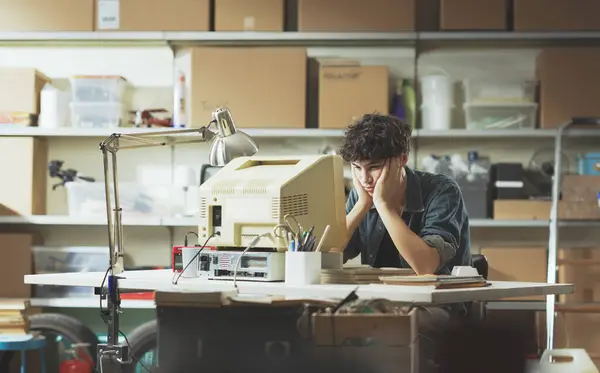 Langweilig Faul Teenager Guy Sitting Desk Die Garage Und Using lizenzfreie Stockfotos