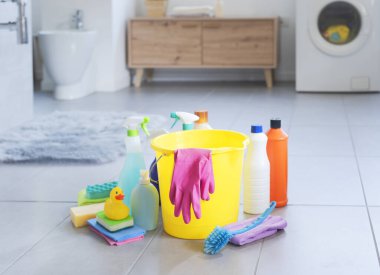 Banyo zemininde çeşitli temizlik malzemeleri ve deterjanlar, hijyen ve temizlik konsepti.