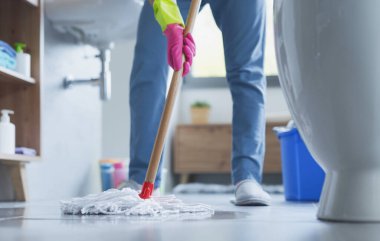 Yerleri paspaslayan ve evini temizleyen bir kadın.