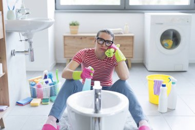 Sıkıcı kadın ev işlerini yapıyor, yerde oturuyor ve banyosunu temizliyor.