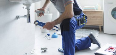 Plumber replacing sink pipes at home, professional service concept clipart