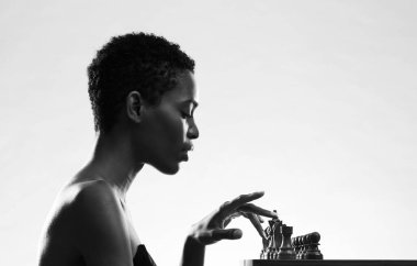 Güzel siyah kadın satranç oynuyor, satranç tahtasındaki taşlara dokunuyor, kopyalama alanı.