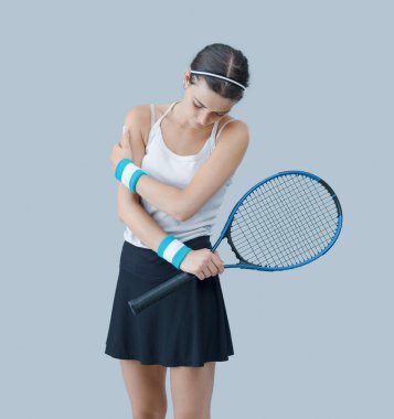 Yaralı genç bayan tenis oyuncusu, omzuna, spor ve sağlık hizmetlerine dokunuyor.