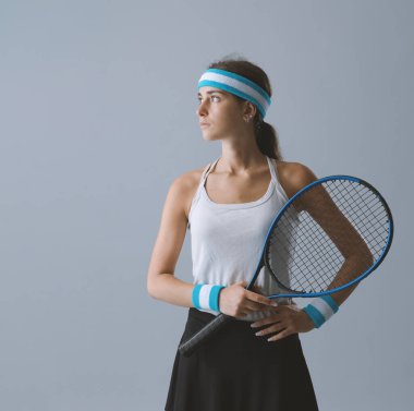 Kendine güvenen bir bayan tenisçinin portresi. Elinde tenis raketi, spor ve yarışma konsepti var.