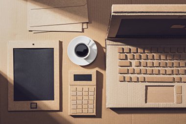 Laptoplu iş masaüstü ve kartondan yapılmış diğer nesneler: sürdürülebilirlik, zanaat ve yaratıcılık kavramı, üst görünüm