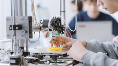 Mühendislik öğrencisi 3 boyutlu yazıcı kullanarak laboratuvarda bir prototip basıyor: eğitim, bilim ve teknoloji konsepti
