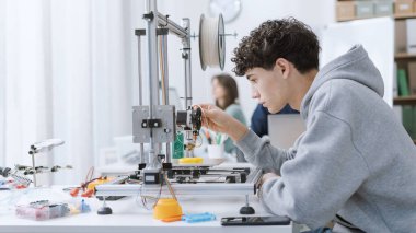Mühendislik öğrencisi 3 boyutlu yazıcı kullanarak laboratuvarda bir prototip basıyor: eğitim, bilim ve teknoloji konsepti