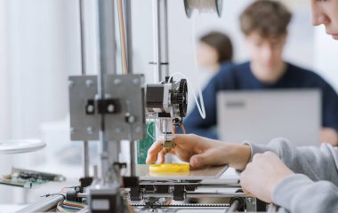 Mühendislik öğrencisi 3 boyutlu yazıcı kullanarak laboratuvarda bir prototip basıyor: eğitim, bilim ve teknoloji konsepti
