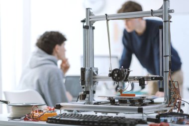 3D baskı laboratuvarında, teknoloji ve eğitim konseptinde öğrenciler birlikte konuşuyorlar