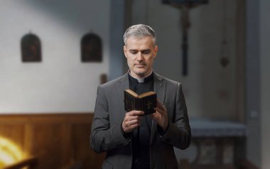 Kilisenin içinde İncil okuyan bir rahibin portresi.