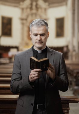 Kilisenin içinde İncil okuyan bir rahibin portresi.