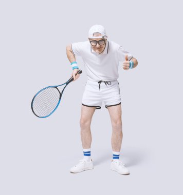 Raketi tutan ve zaferini kutlayan komik inek tenisçi beyaz arka planda tek başına kameraya bakıp gülümsüyor.