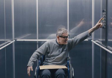 Tekerlekli sandalyedeki adam asansörle ilgili sorunlar yaşıyor, erişilemezlik kavramı yok.