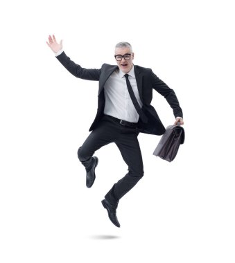 Elinde evrak çantası olan koyu renk takım elbiseli bir işadamı başarısını kutlarken sevinçle atlıyor..