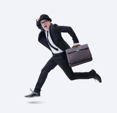 Melon şapka takan ve elinde evrak çantası olan bir işadamı, beyaz bir arka planda korkmuş ve korkmuş bir şekilde kaçar..