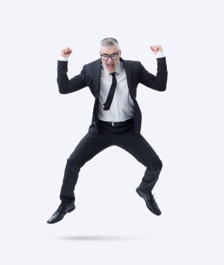 Koyu takım elbiseli bir işadamı başarısını kutlarken sevinçle atlıyor..