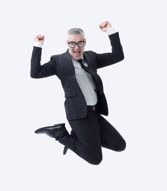 Koyu takım elbiseli bir işadamı başarısını kutlarken sevinçle atlıyor..