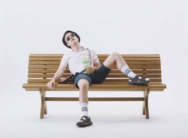 Bir bankta oturan orta yaşlı erkek turist sıcaktan muzdarip. İklim değişikliği kavramı.