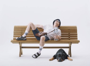 Bir bankta oturan orta yaşlı erkek turist sıcaktan muzdarip. Küresel ısınma kavramı.