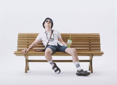 Bir bankta oturan orta yaşlı erkek turist sıcaktan muzdarip. Küresel ısınma kavramı.