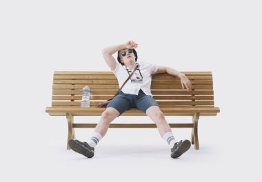 Bir bankta oturan orta yaşlı erkek turist sıcaktan muzdarip. İklim değişikliği kavramı.