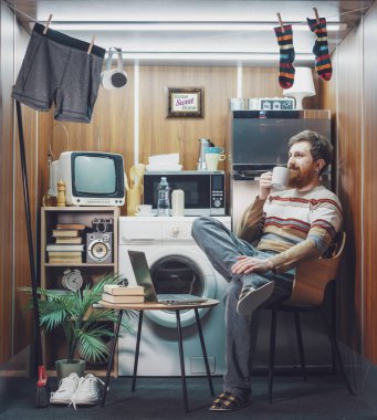 Küçük stüdyo dairesinde kahve içen mutlu bir adamın portresi.